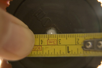 Photo of lens cap with pinhole, plus ruler for calibrating